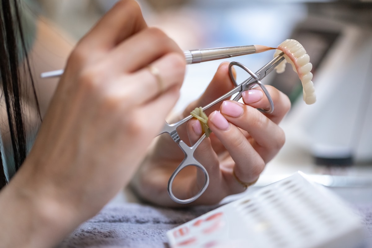 Profissional de laboratório confeccionando prótese dentária